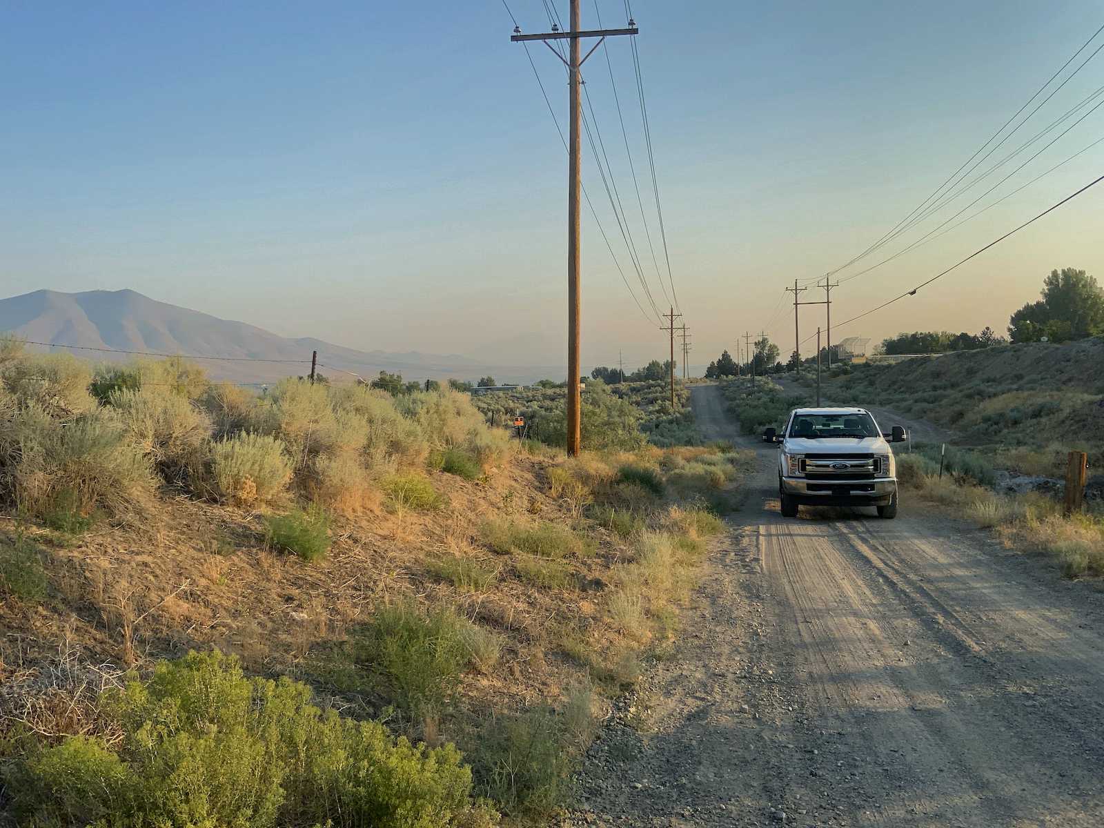 Patrol truck on a high-desert right-of-way road beneath a distribution line in Nevada